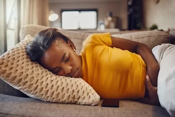 stomach pain illness sickness causing tired young sleepy black woman sleep nap rest couch home relaxed sick ill female suffering from covid fatigue while napping 590464 77868