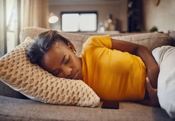 stomach pain illness sickness causing tired young sleepy black woman sleep nap rest couch home relaxed sick ill female suffering from covid fatigue while napping 590464 77868 jpg
